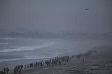 Más de 200 líderes religiosos y de organizaciones civiles estadounidenses caminaron en una columna sobre la costa para llegar al muro que divide San Diego y Tijuana. Dos helicópteros del Ejército de Estados Unidos acompañaban su trayecto. 