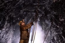 A miner drills in drift 