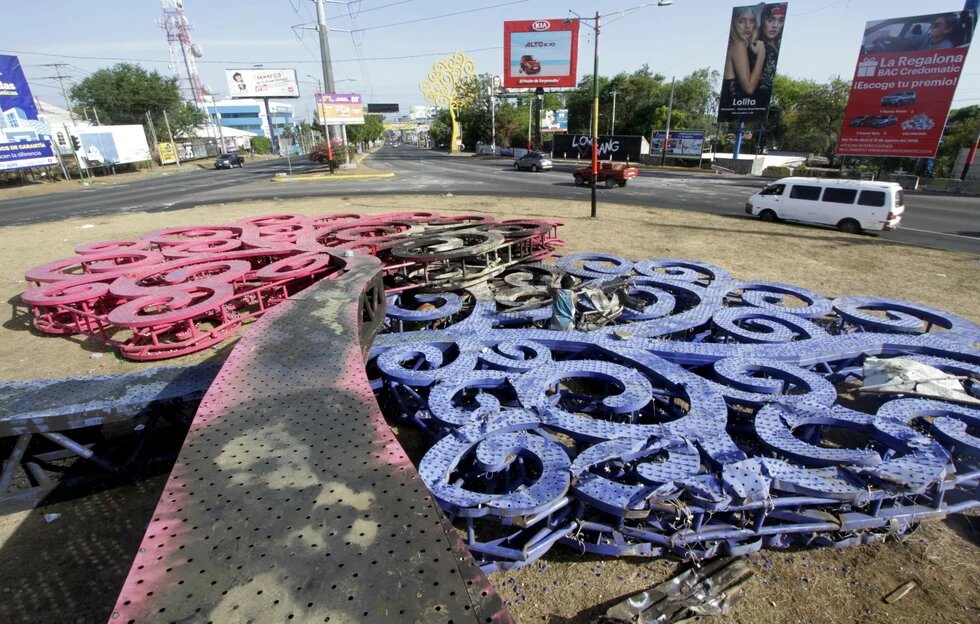 Un grupo de hombres cortó piezas metálicas para vender en el mercado los restos del árbol de acero, monumentos simbólicos del gobierno del Frente Sandinista nicaragüense. Los monumentos fueron incendiados y derribados durante una protesta contra las reformas del gobierno en el Instituto de Seguridad Social (INSS), en Managua el 22 de abril de 2018.